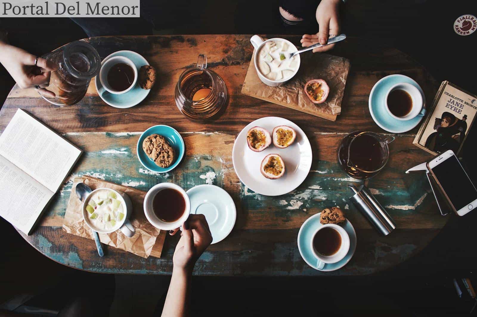 Person Sitting Near Table With Teacups and Plates