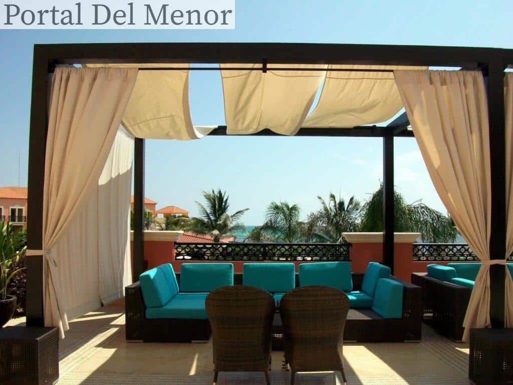 Elegant outdoor seating area on a sunlit rooftop overlooking the ocean.