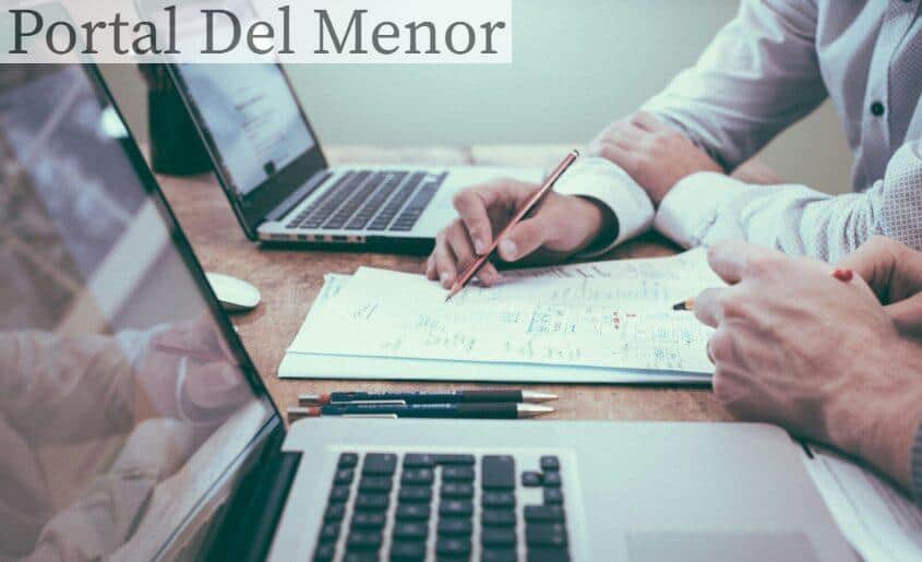 person holding pencil near laptop computer